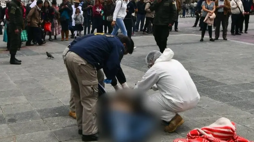 Efectivos policiales realizan el levantamiento legal del cad&aacute;ver en la plaza San Francisco. APG