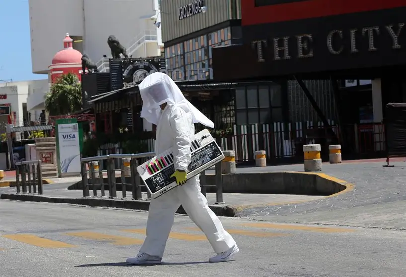 Un turista recorre las calles de M&eacute;xico con un traje sanitario. EFE