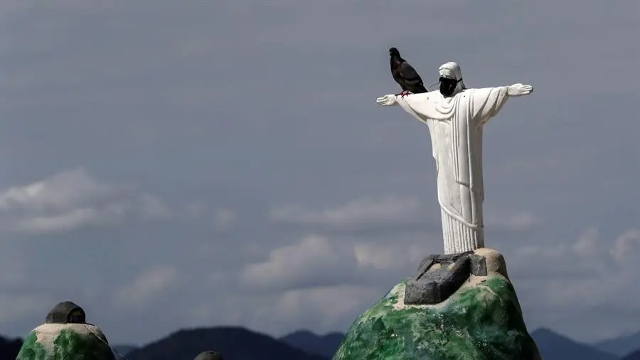 Vista de una estatua de una r&eacute;plica del Cristo Redentor con un tapabocas, en la playa de Copacabana, R&iacute;o de Janeiro.       FUENTE: EFE.