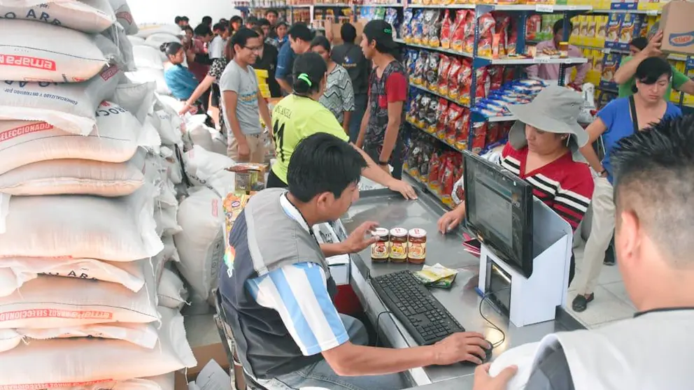 Un funcionario de Emapa atiende a los clientes en un supermercado estatal. Archivo
