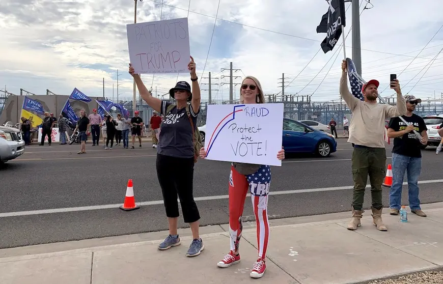 Seguidores del presidente Trump sostienen pancartas y banderas durante una protesta este viernes en Phoenix, Arizona. EFE