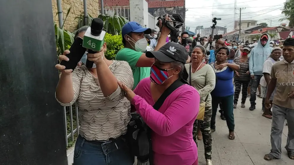 La periodista de Canal 48 de la ciudad de Montero, Vivian P&eacute;rez, trata de protegerse del ataque de padres de familia que reclamaban un bono escolar en especie. Diario Zona Norte de Montero