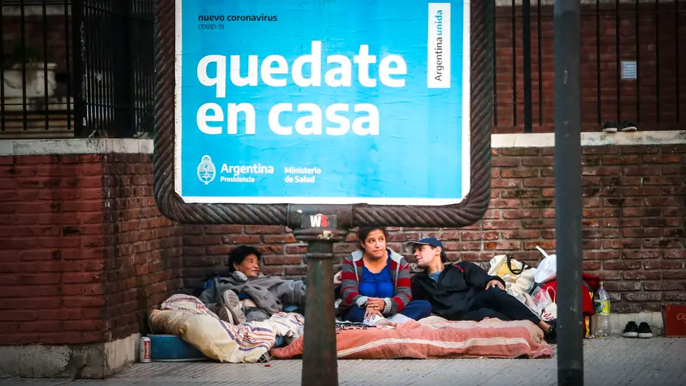 Fotografía tomada por el fotógrafo Juan Ignacio Roncoroni el 3 de mayo de 2020 que muestra a una familia en condición de calle tras una publicidad que invita a la ciudadanía a quedarse en casa, en Buenos Aires (Argentina). EFE