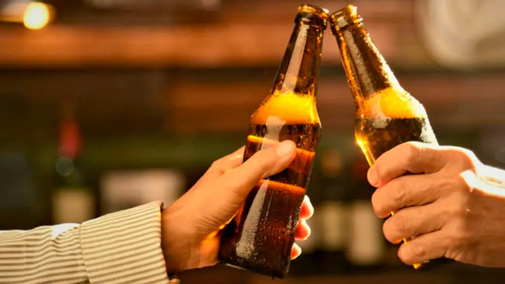 Un brindis con botellas de cerveza.