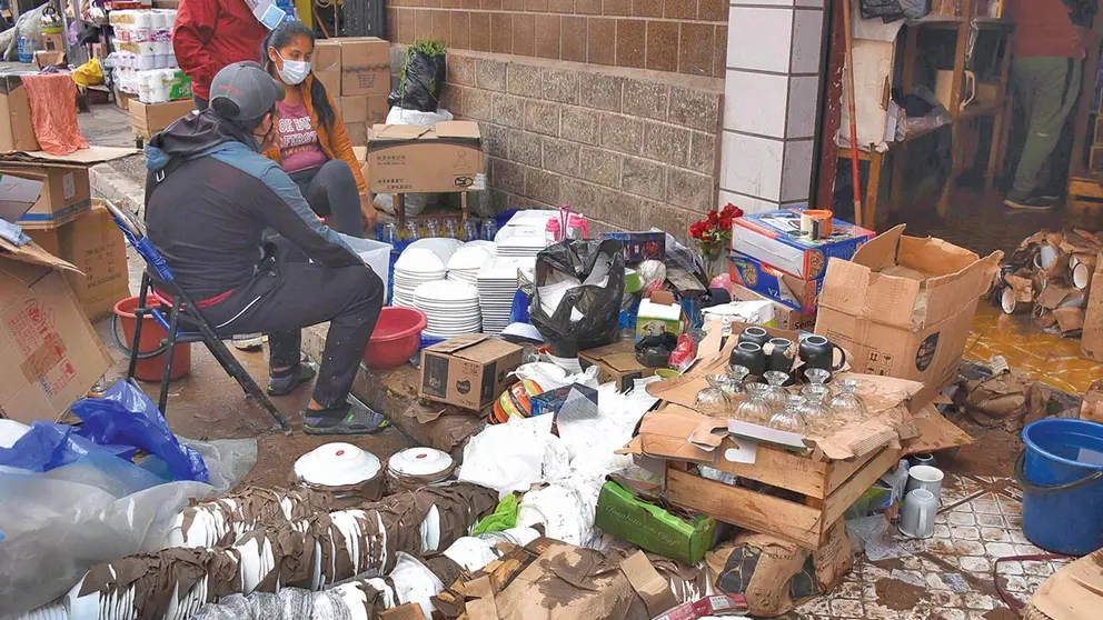 Comerciantes recogen parte de su mercadería, ayer. APG