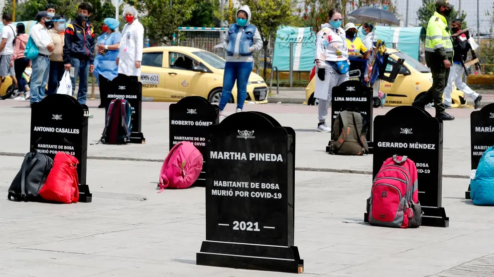 Habitantes de la localidad de Bosa observan lápidas con nombres de algunas de las personas fallecidas por la COVID-19, en el sur de Bogotá (Colombia). EFE