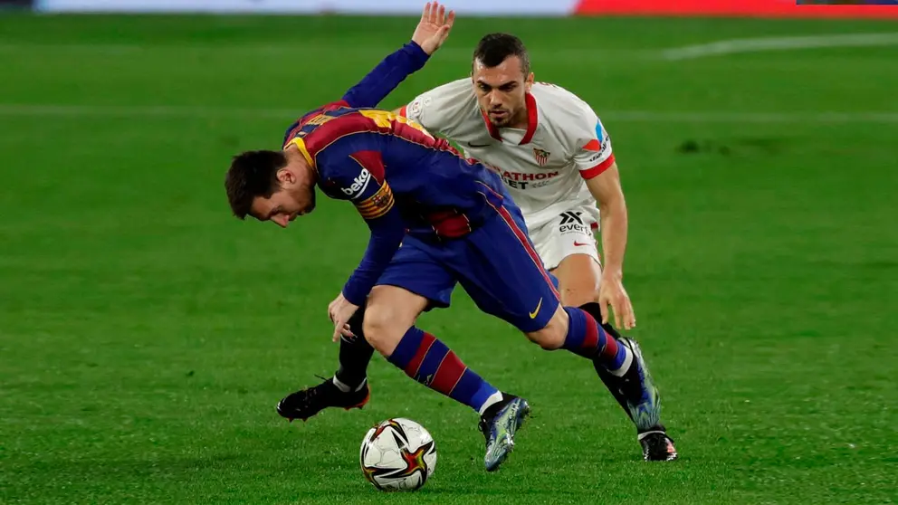 El delantero argentino del FC Barcelona, Leo Messi (i), intenta controlar el balón ante el centrocampista del Sevilla, Joan Jordá, durante el encuentro correspondiente a la ida de las semifinales de la Copa del Rey. EFE