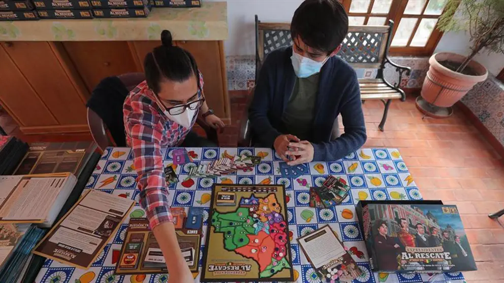 Los hermanos bolivianos Diego (i) y Juan Jos&eacute; (d) Pe&ntilde;aranda, explican el juego de mesa que crearon: "Expresidentes al rescate", el 5 de febrero de 2021 en La Paz (Bolivia).  EFE
