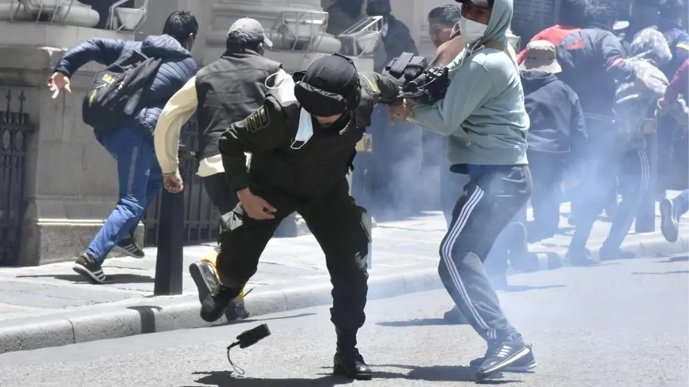 Uno de los manifestantes golpea a un polic&iacute;a, en La Paz. APG  policial.jpg