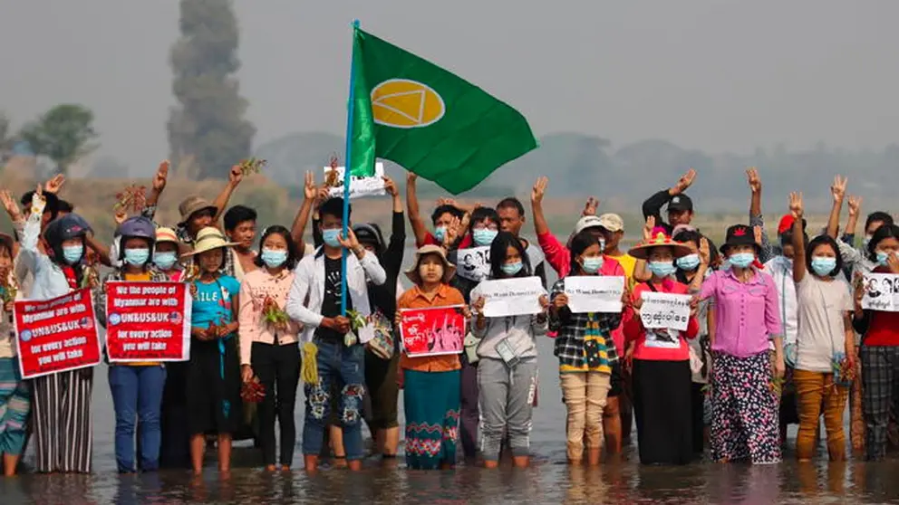 Los manifestantes muestran el saludo de tres dedos y sostienen pancartas durante una protesta contra el golpe militar en el río Sittaung, municipio de Leway en Naypyitaw, Birmania. EFE