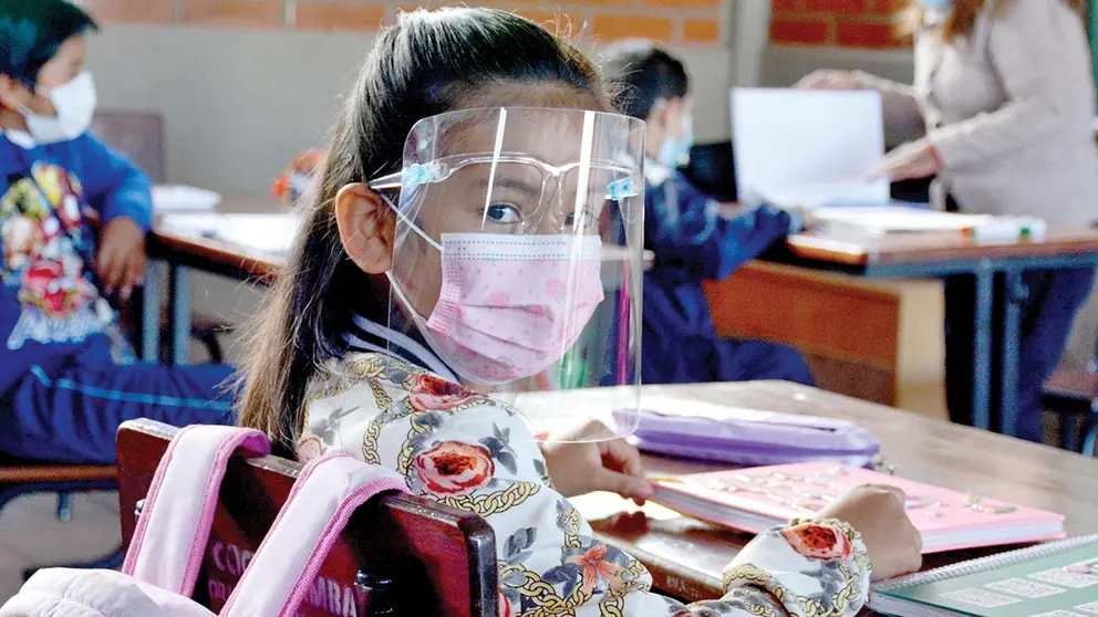 Una escolar pasa clases con barbijo y protector facial. DICO SOLÍS