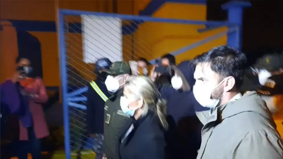 Jeanine &Aacute;&ntilde;ez a su llegada a dependencias policiales resguardada por el propio Ministro de Gobierno y el comandante de la Polic&iacute;a Nacional, Jhonny Aguilera. Captura de video