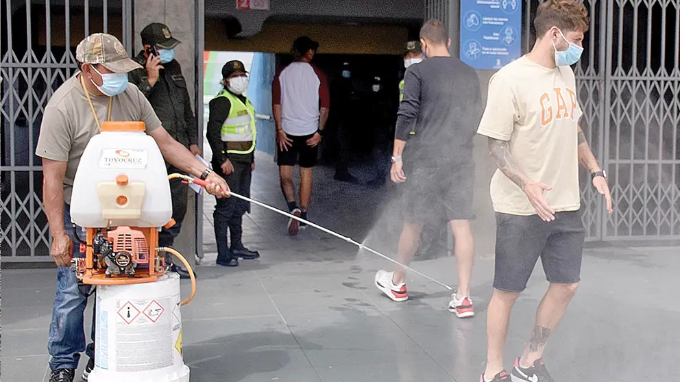 Una persona es desinfectada antes de ingresar a un recinto deportivo. DICO SOLÍS