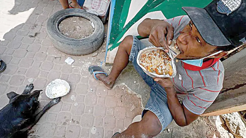 Un morador de una favela de Sao Paulo (Brasil) recibe una donación de comida. EFE