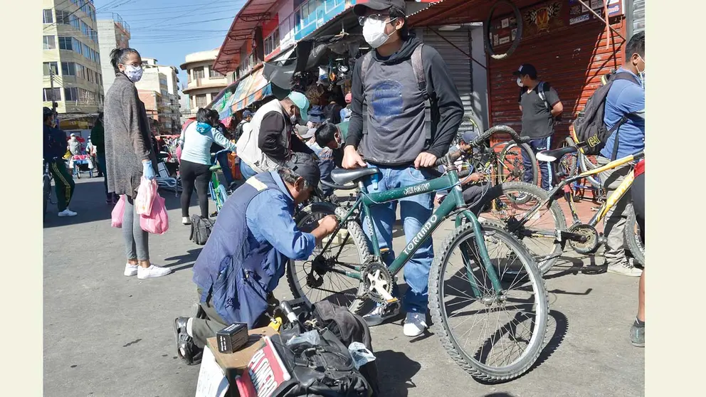 Un joven hace reparar su bicicleta en la calle. NOÉ PORTUGAL