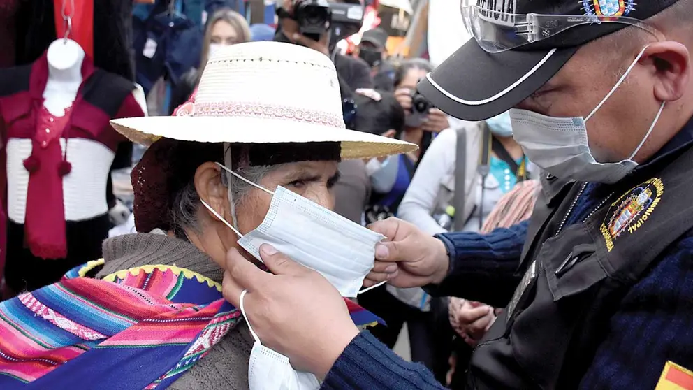 Un funcionario de la Intendencia de Cochabamba pone un barbijo a una mujer. DICO SOLÍS
