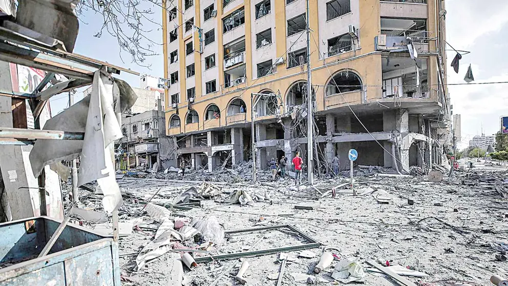 Varios palestinos observan los daños en la torre Al-Jawhara tras un ataque aéreo israelí.  EFE