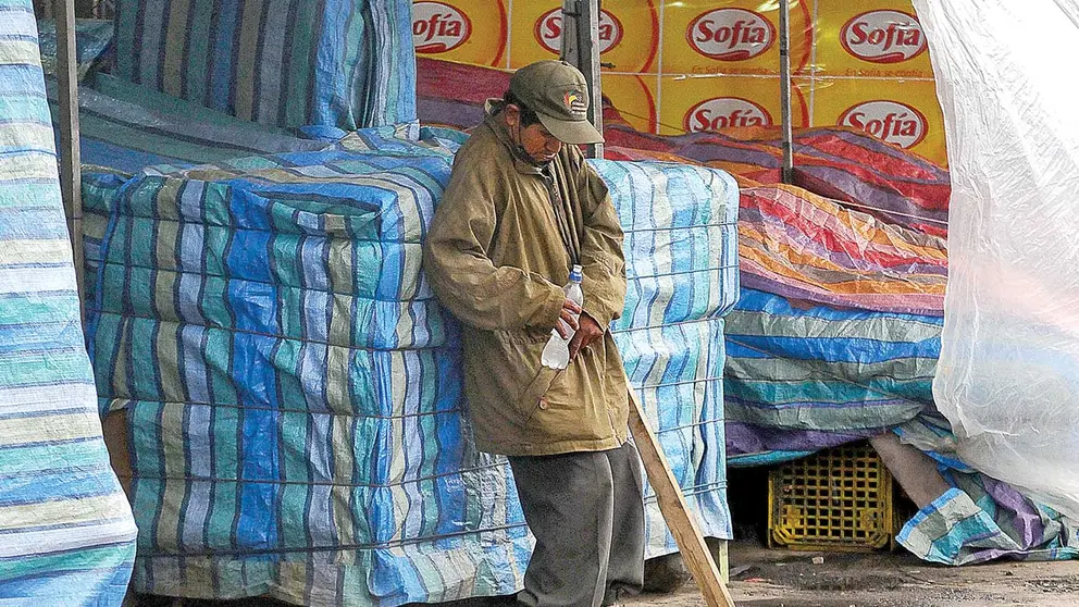 Una persona en situación de calle descansa en un mercado de Cochabamba. DICO SOLÍS