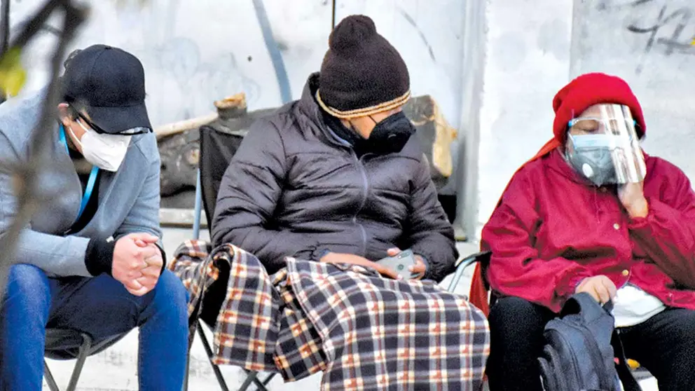Dos personas se protegen del frío con ropa abrigada y mantas. DICO SOLÍS