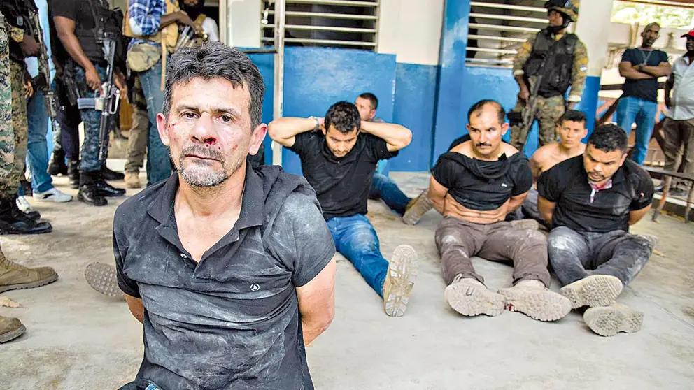 Policías custodian hoy a un grupo de sospechosos de haber participado en el asesinato del presidente haitiano.  EFE