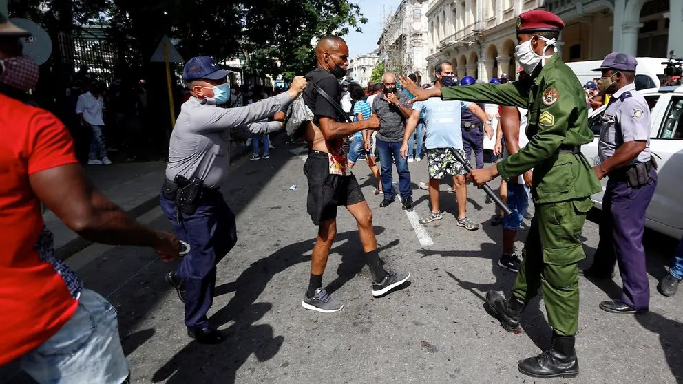 Policías arrestan a un hombre cuando personas se manifiestan en una calle en La Habana (Cuba). EFE