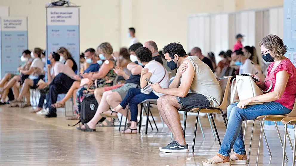 Una fila de personas en una sala del centro de  vacunaci&oacute;n masiva en Espa&ntilde;a. EFE