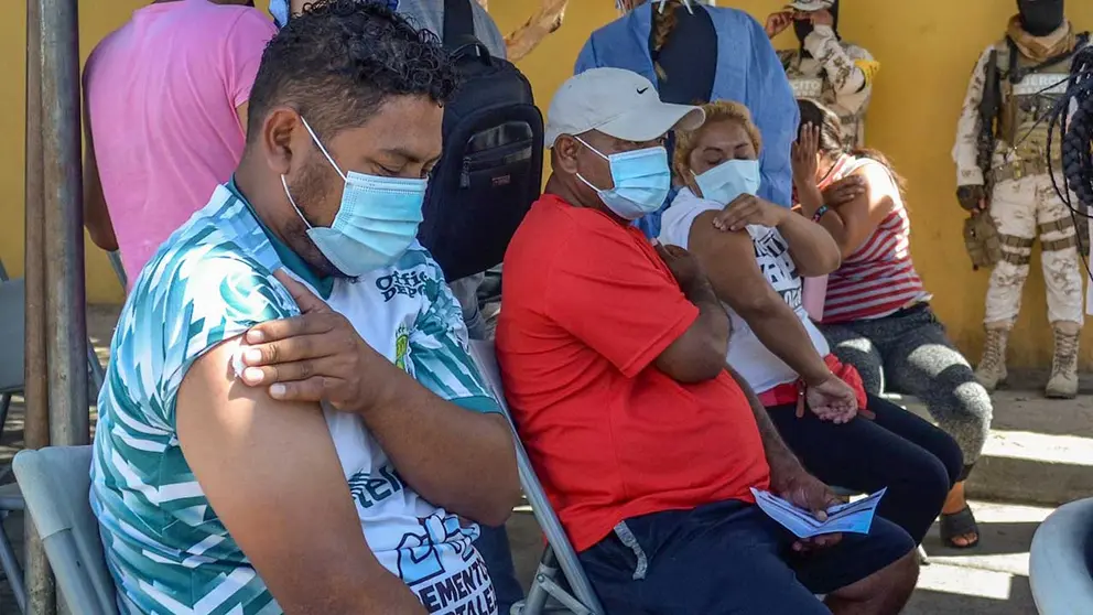 Varias personas migrantes reposan tras ser vacunados contra la Covid-19 hoy, en Tijuana, estado de Baja California (México). EFE