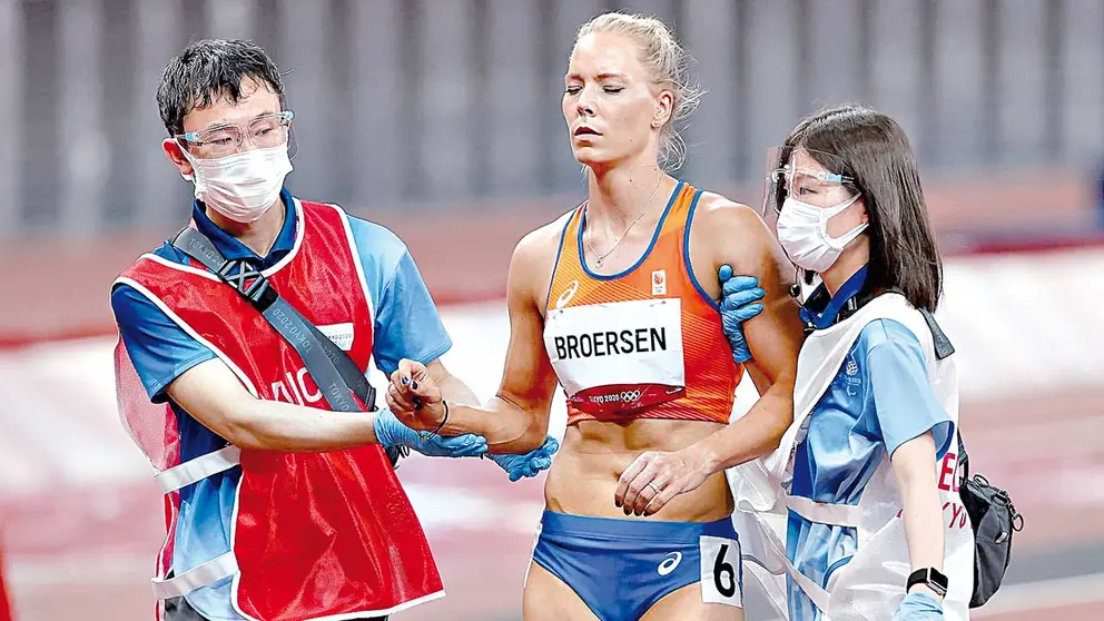 La asistencia a una atleta durante una prueba de pista. EFE