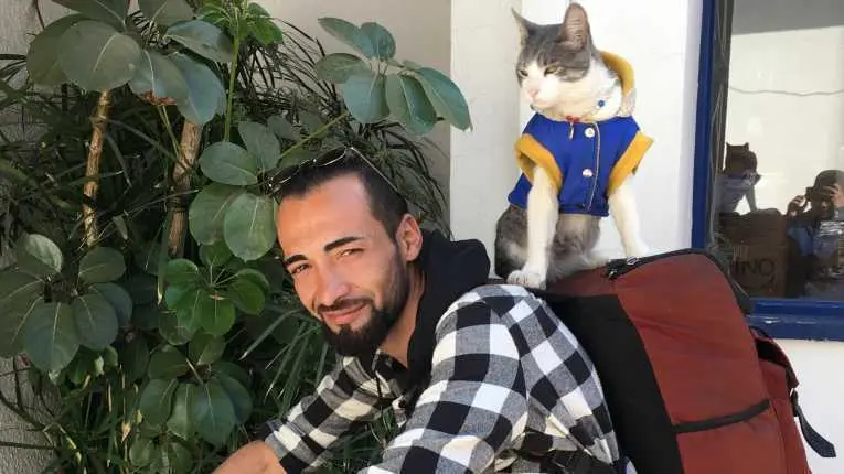 Bella y Jhon, el gato y el mochilero colombiano, durante una visita a las instalaciones del peri&oacute;dico OPINI&Oacute;N.