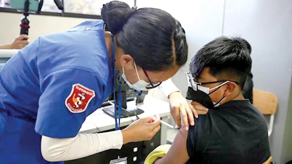Menor, de entre 12 y 15 años, es vacunado contra la COVID-19 en Ecuador.       EFE