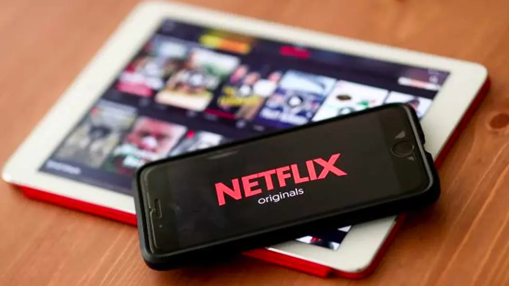 En la imagen de archivo el registro de un logo de Netflix en un teléfono móvil sobre una tablet con la plataforma en mención abierta. EFE