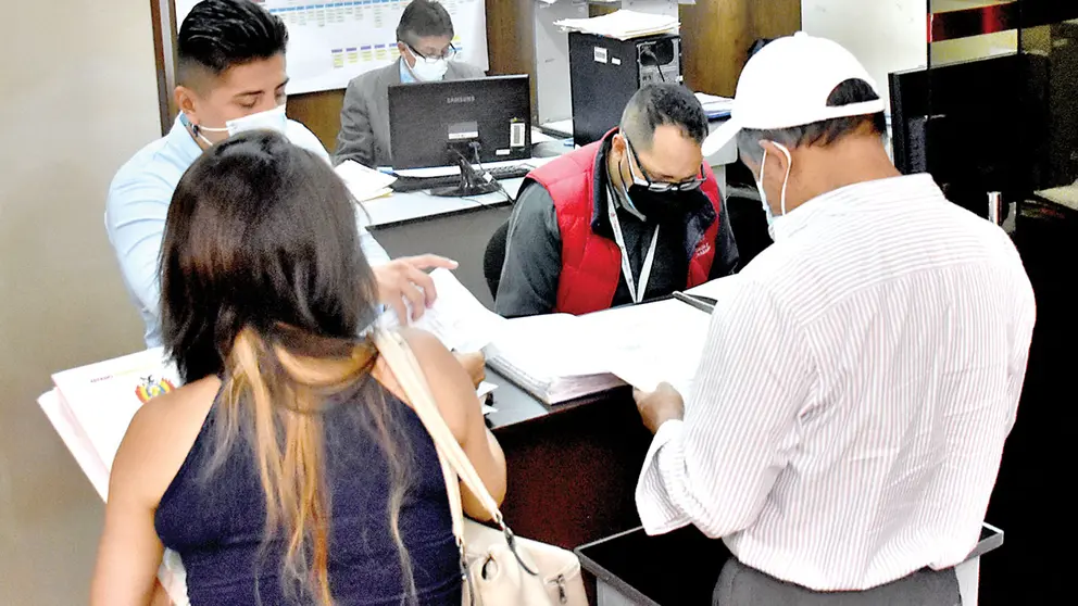 Funcionarios públicos atienden a ciudadanos que hacen trámites. DICO SOLÍS