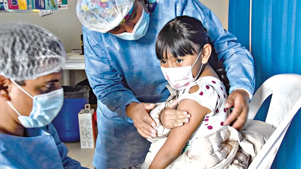 Una niña se prepara para recibir una vacuna contra la COVID-19./ NOÉ PORTUGAL
