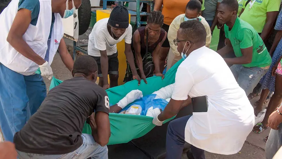 Varias personas cargan a una persona herida tras la explosión este martes de un camión para su traslado vía aérea a Puerto Príncipe, hoy, en Cap-Haitien (Haití). EFE