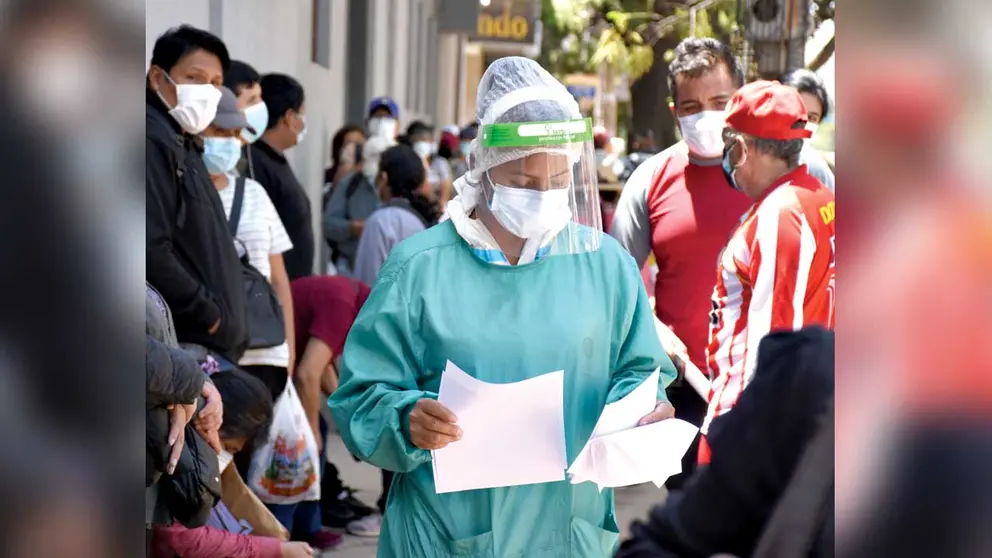 Una enfermera de la CNS pide documentación a decenas de asegurados que hacen fila por vacunas y pruebas COVID. NOÉ PORTUGAL
