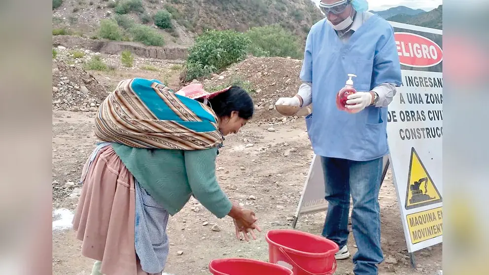 Una comunaria de Sicaya lava sus manos en recipientes portátiles de agua. AlcaldÍa de Sicaya.