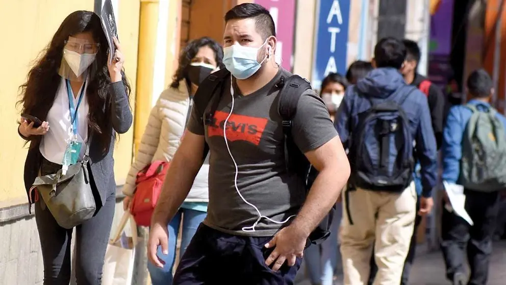 Personas caminan por la calle protegidas con barbijos. DICO SOL&Iacute;S
