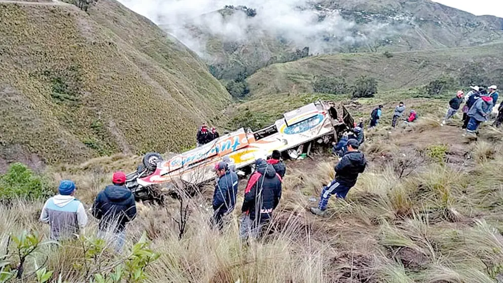 El bus embarrancado junto a grupos de voluntarios que ayudaron a rescatar a los heridos.      POLICÍA BOLIVIANA