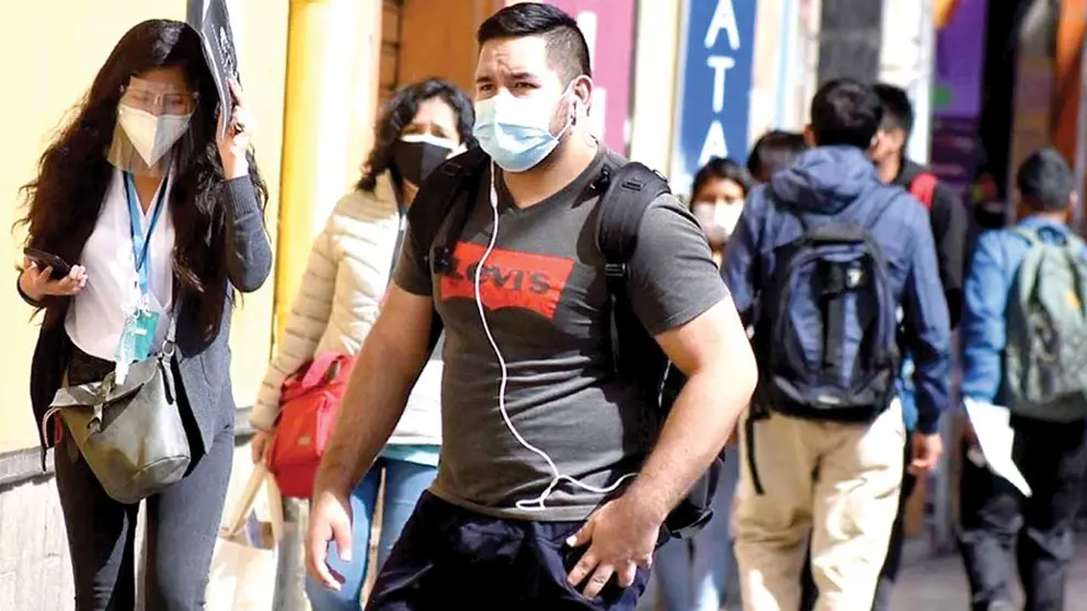Personas circulan por una calle de Cochabamba con barbijos. ARCHIVO