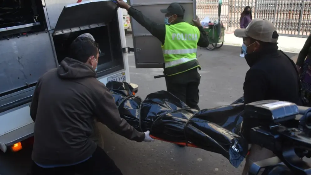 El momento en que oficiales proceden al levantamiento del cad&aacute;ver del hombre victimado con arma de fuego, en la calle Uruguay casi Lanza. DICO SOL&Iacute;S