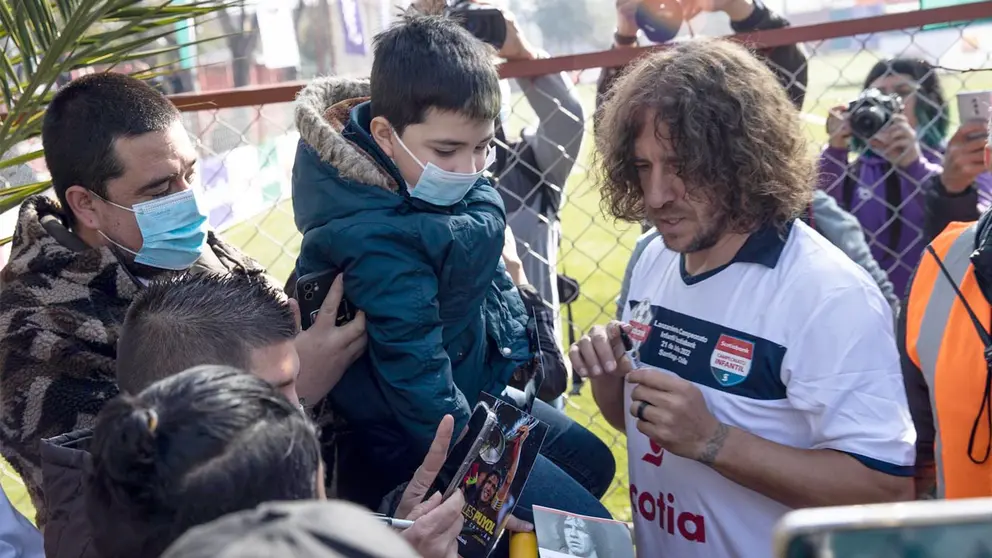 El exjugador de fútbol español Carles Puyol firma autógrafos y saluda aficionados, hoy, en el estadio Arturo Rojas Nogales de la ciudad de Santiago (Chile). EFE