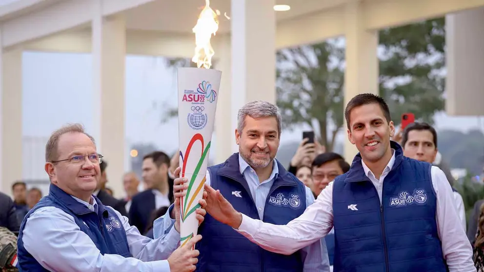 Camilo Pérez López M.(i), presidente del Comité Olímpico Paraguayo; Mario Abdo Benítez (c), presidente de Paraguay, y Diego Galeano H., ministro de Deportes, posan con la antorcha de los XII Juegos Suramericanos en Luque (Paraguay). EFE