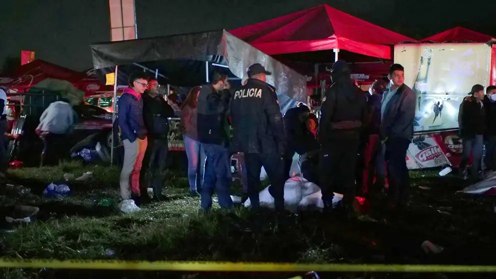 Agentes de policía resguardan los cuerpos de algunas víctimas tras una estampida en la madrugada de hoy, en Quetzaltenango (Guatemala). EFE
