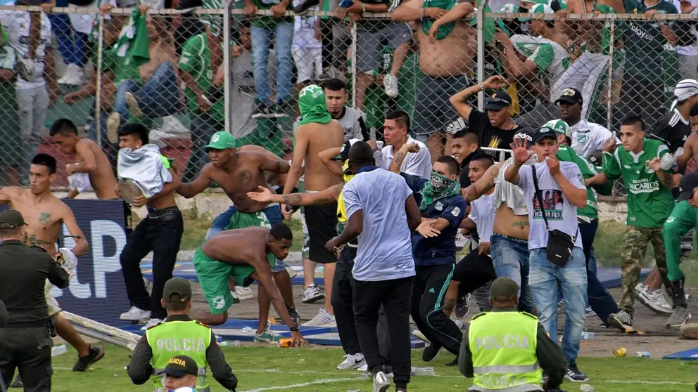 Fotografía cedida hoy por el diario colombiano El País que muestra a hinchas del Deportivo Cali mientras invaden la cancha, durante un partido contra el Cortuluá por la jornada 13 del torneo Clausura de la liga colombiana. EFE