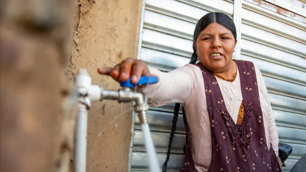 Una de las vecinas de la OTB Alto Nueva Esperanza abre una pileta, tras la inauguraci&oacute;n del servicio de agua en dicha zona. ALCALD&Iacute;A DE COCHABAMBA