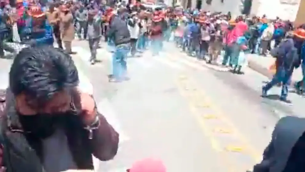 Periodistas tratan de protegerse frente al estallido de dinamita lanzada por mineros cooperativistas de Potos&iacute;. CAPTURA DE VIDEO