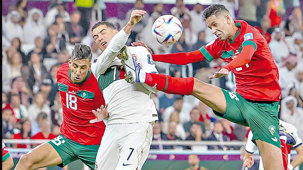 Cristiano Ronaldo (c) pugna la posesión del balón con dos jugadores marroquíes. EFE