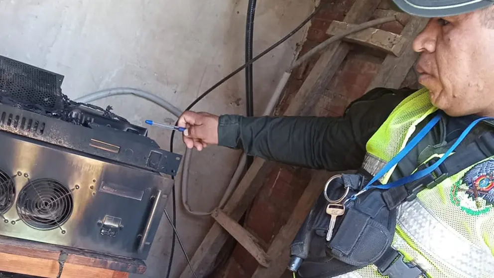 Un polic&iacute;a observa uno de los equipos de transmisi&oacute;n radial incendiados. RADIO YUNGAS