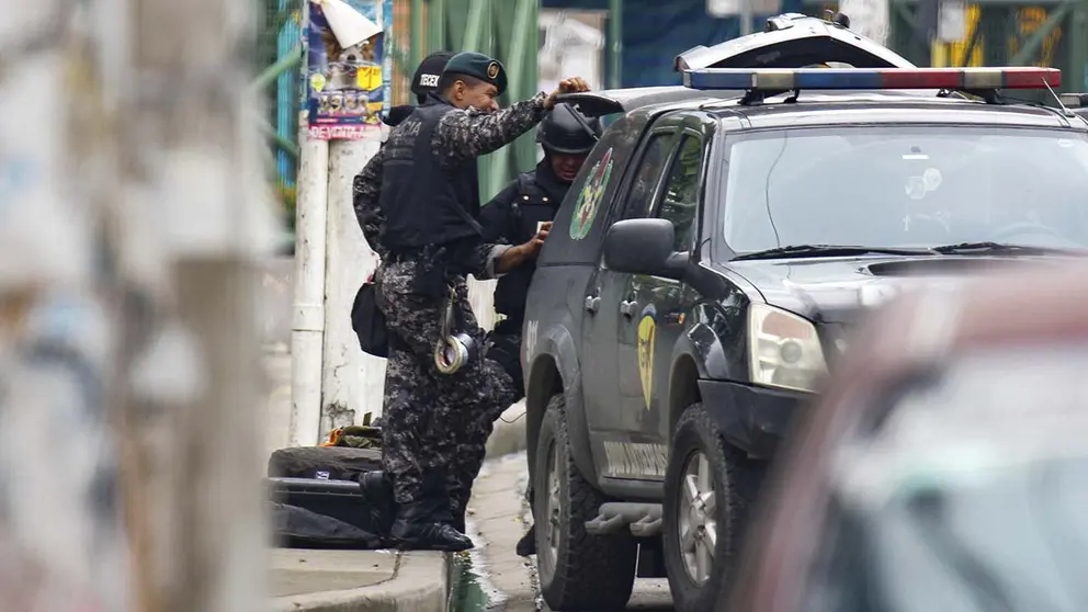 Integrantes de la polic&iacute;a durante un operativo para desactivar un dispositivo explosivo adherido al cuerpo de un hombre hoy, en Guayaquil (Ecuador)./ EFE