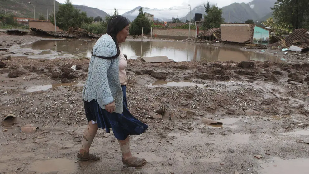 Fotograf&iacute;a de archivo en la que se registr&oacute; a una mujer al caminar por una calle anegada en el poblado de Urubamba (Per&uacute;)./ EFE